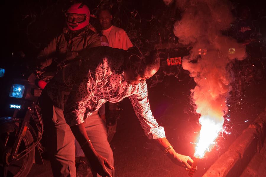 Un hombre enciende un cohete durante la celebración del día de la independencia de Haití. (EFE)
