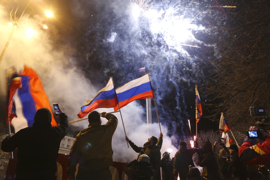Personas celebran el reconocimiento de independencia ondeando banderas de Rusia en el centro de Donetsk. (AP)