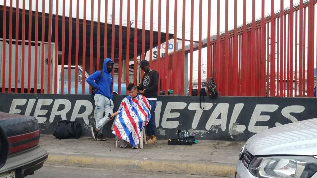 En Monterrey, migrantes haitianos improvisan barbería en la calle. Foto: Especial.