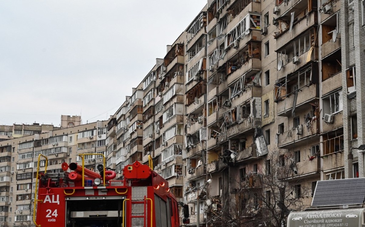 Bomberos trabajan en un edificio residencial dañado en Kiev, donde supuestamente cayó un proyectil.| AFP