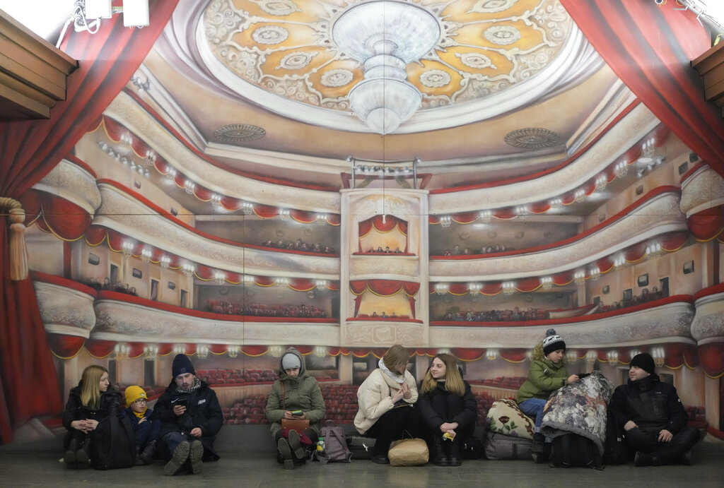Un grupo de personas descansan apoyadas contra una pared del metro de la capital ucraniana. (AP)