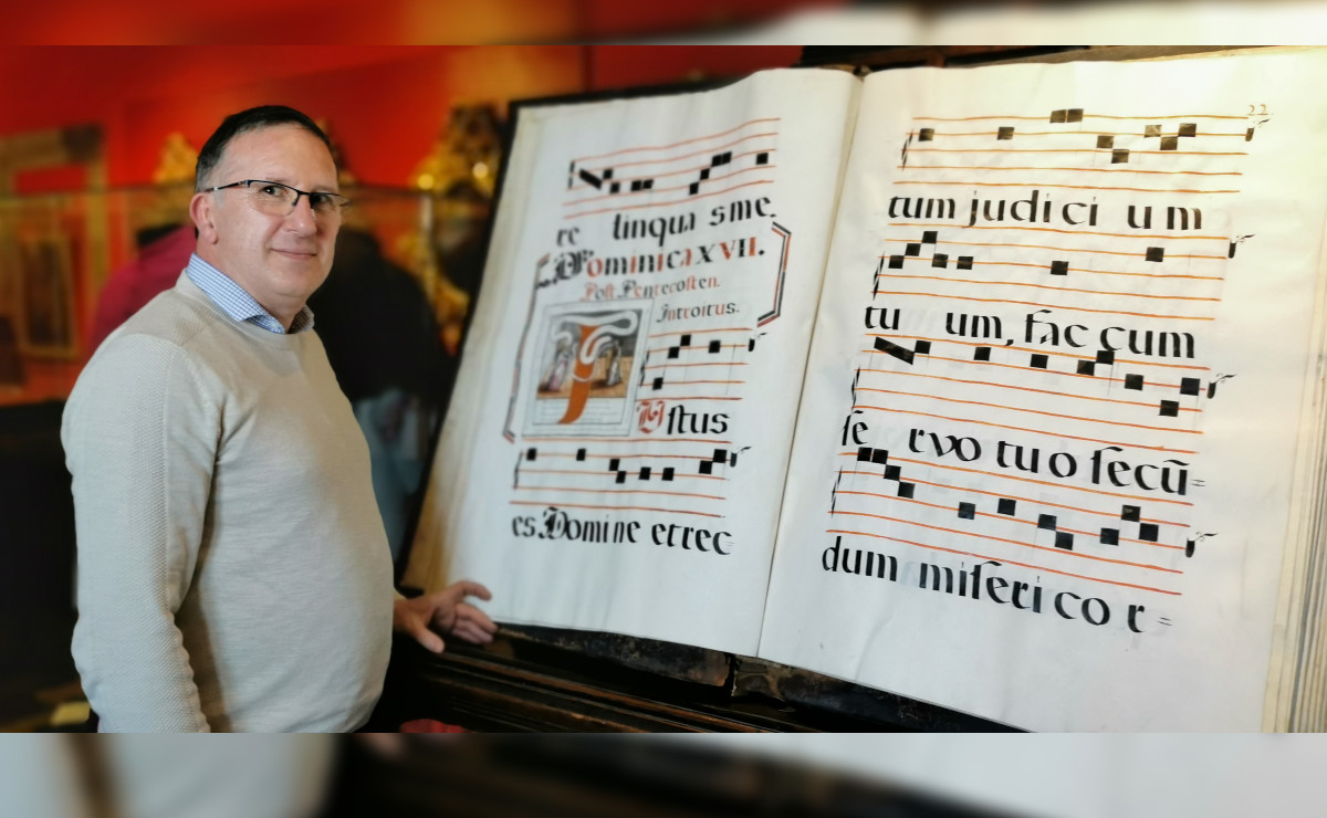 Jean Christopher Candau y uno de los libros de música del Archivo de la Catedral Metropolitana de Guadalajara (Cortesía)