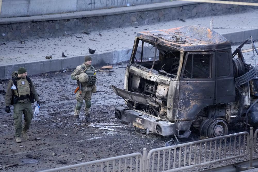Soldados ucranianos inspeccionan un vehículo tras un ataque aéreo ruso sobre Kiev, en Ucrania | AP