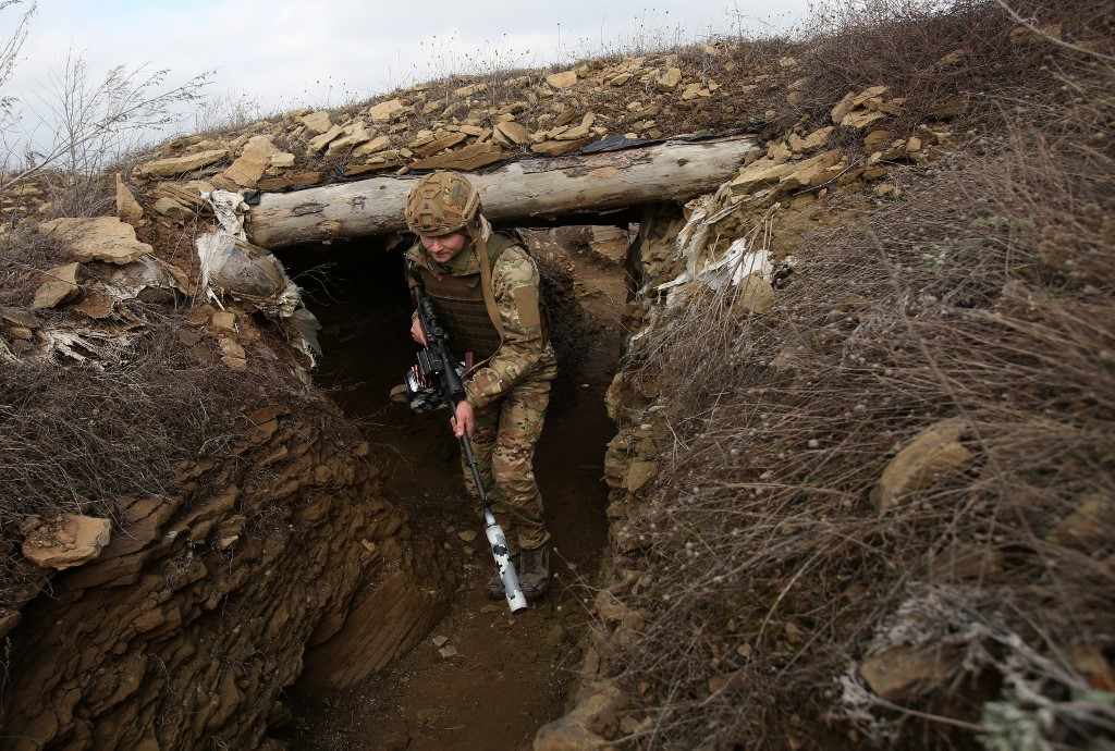 Un militar ucraniano camina a lo largo de una trinchera. (AFP)