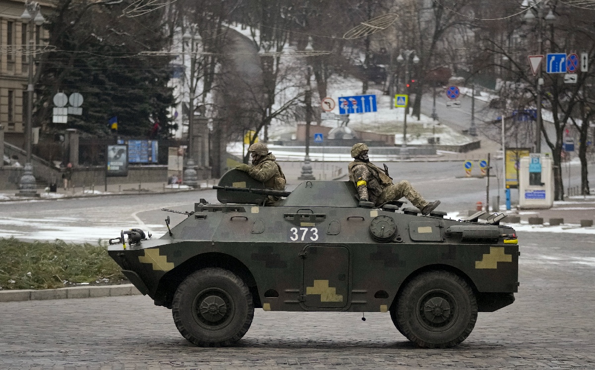 Militares ucranianos viajan sobre un vehículo blindado que circula por una avenida en Kiev. | AP
