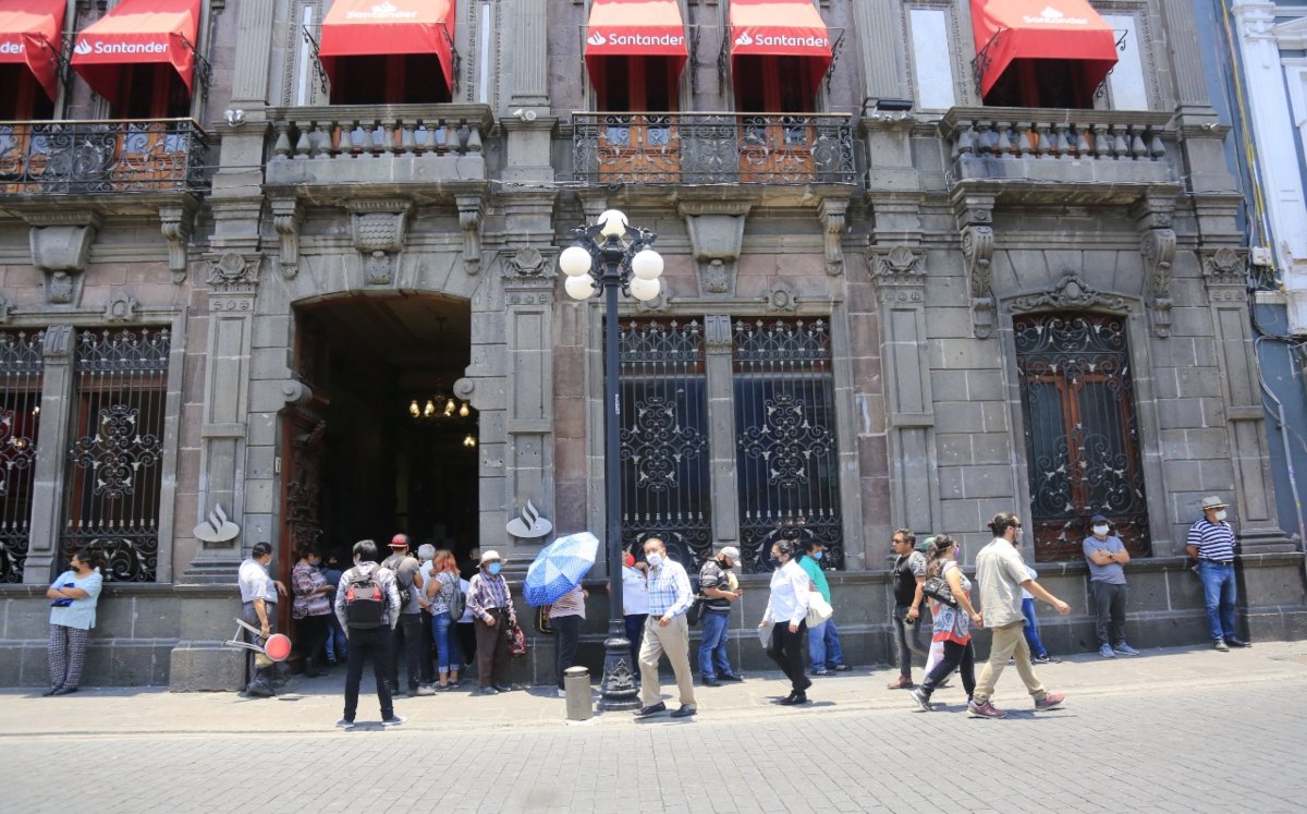 Personas hacen fila al exterior de un banco en Puebla |  Andrés Lobato