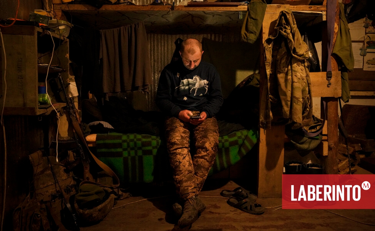 Un militar ucraniano de primera línea lee las noticias en su celular. (Foto: Vadim Ghirda | AP)