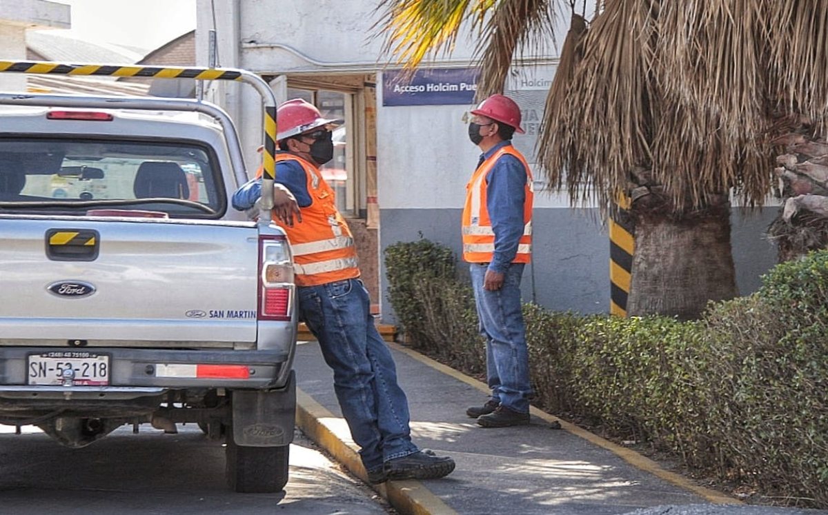 Dos trabajadores se encuentran en la entrada de una empresa | Andrés Lobato