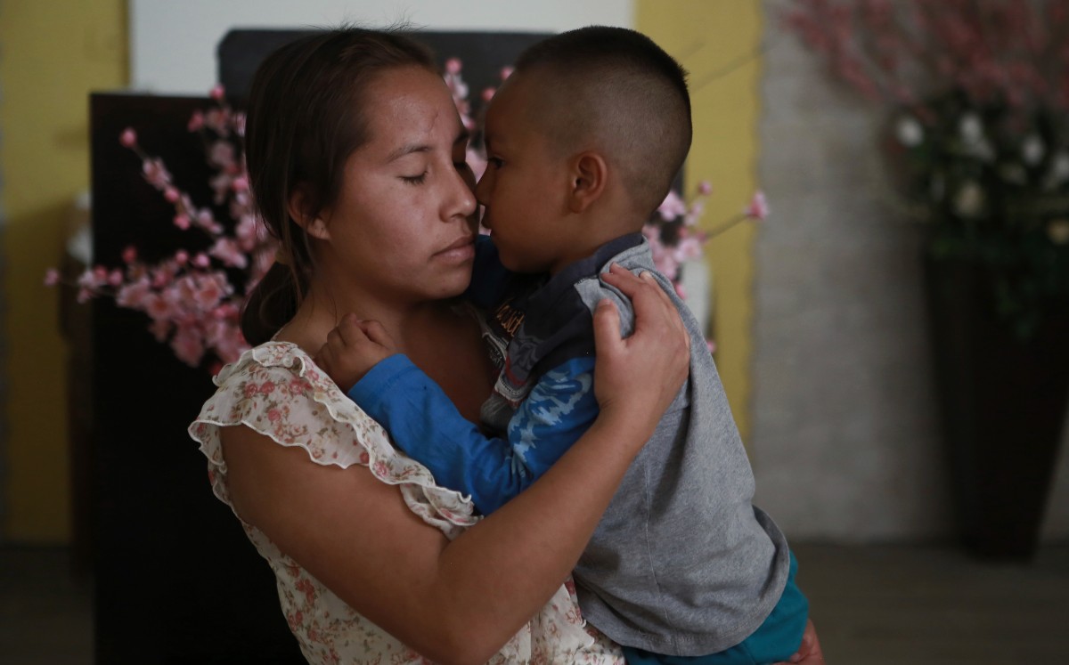 Una mujer abraza a un niño en el albergue del Buen Samaritano. | AP