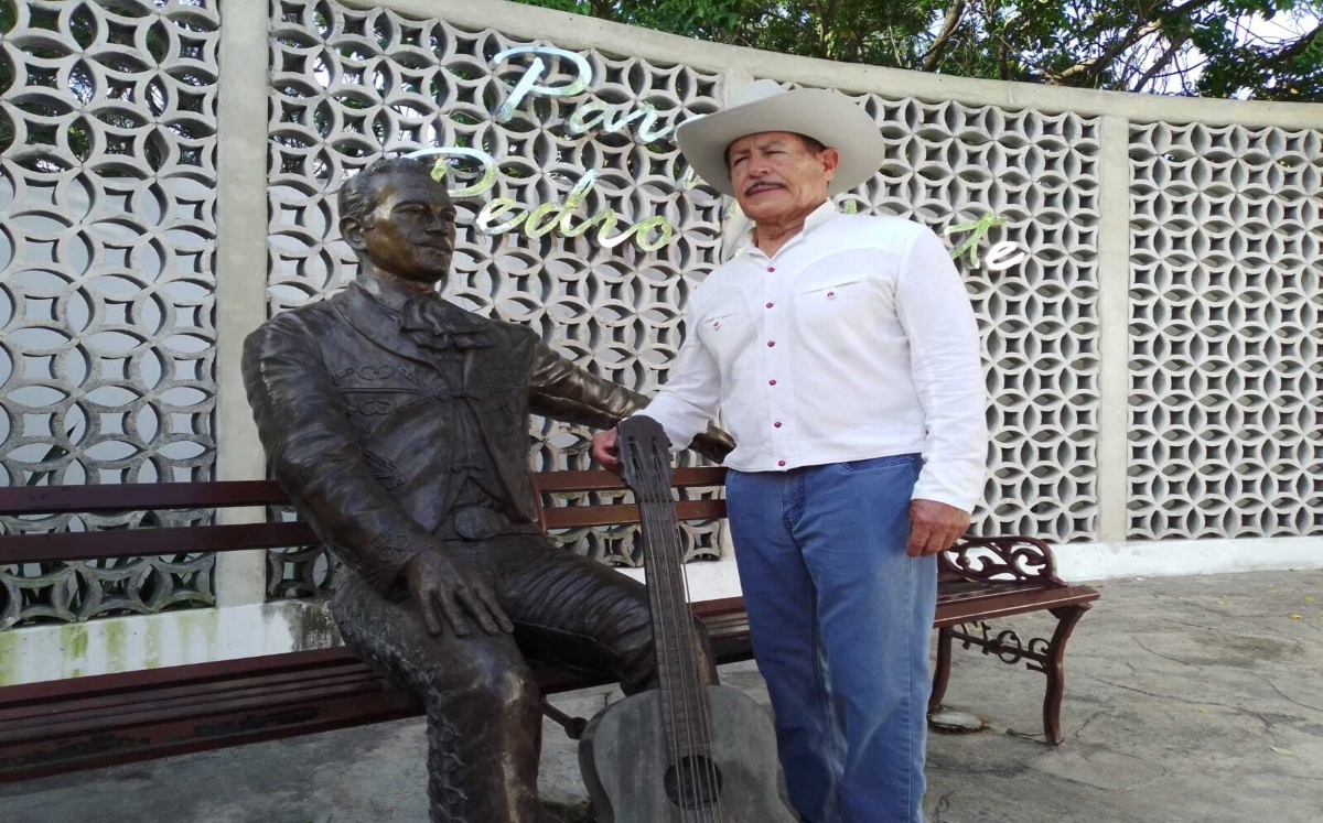 Armando Infante junto a estatua de su padre