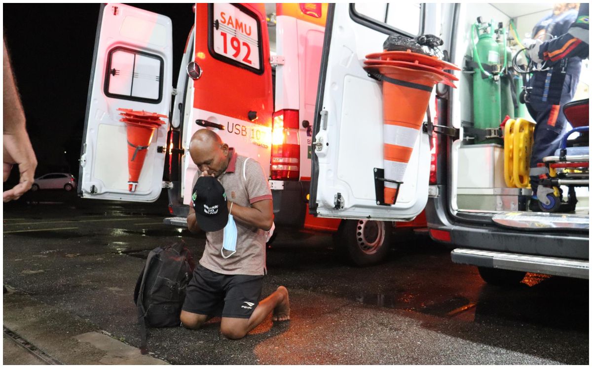 Fotografía cedida por la Marina de Brasil que muestra a una persona que reza tras ser rescatada