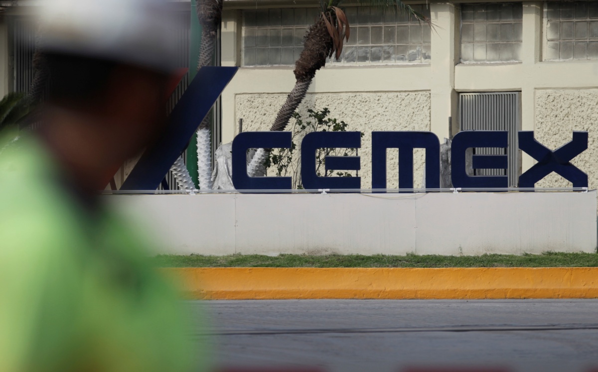 Un trabajador pasa frente a la entrada principal de una planta de hormigón de Cemex, en Monterrey. Junio de 2021. Foto: (Reuters)