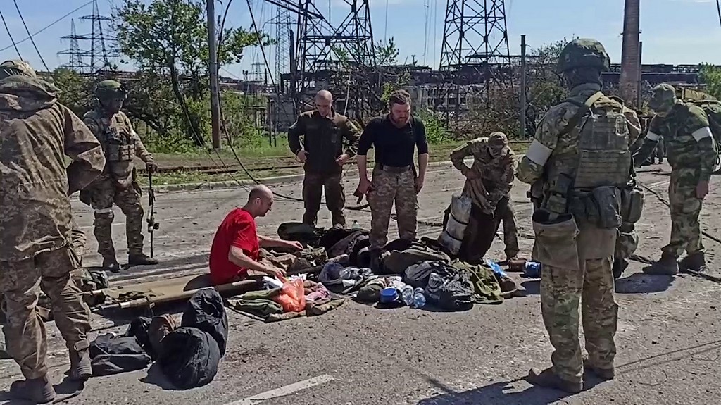 Militares ucranianos mientras son registrados por personal prorruso después de salir de la planta siderúrgica Azovstal. (AFP)