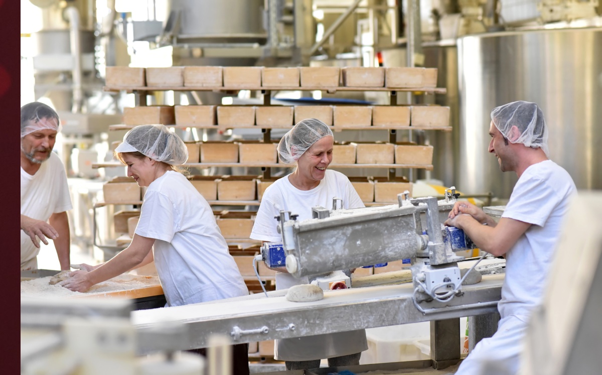 Trabajadores en la producción industrial de productos de panadería en una línea de montaje. Foto: (Shutterstock)
