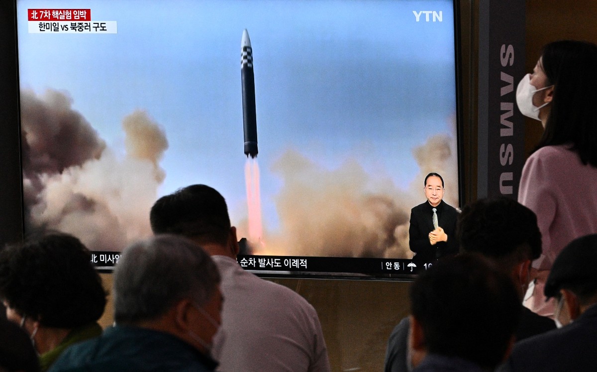 Una transmisión de noticias con imágenes de archivo de una prueba de misiles de Corea del Norte. (AFP)