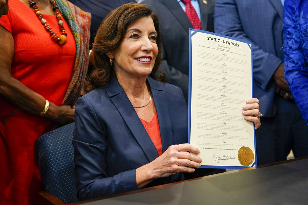 Kathy Hochul, gobernadora de Nueva York, firmando la ley contra las armas a menores en el estado. (AP)