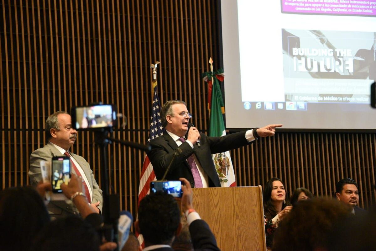 El canciller Marcelo Ebrard usa el micrófono en una charla con migrantes mexicanos en Los Ángeles. (Twitter @m_ebrard)