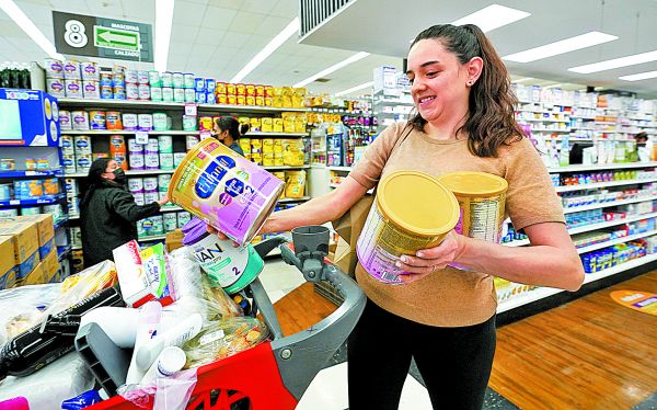 Ante la escasez, una mujer compra varias latas de leche infantil. Gregory Bull/AP