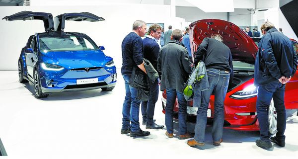 Diversas personas revisan los coches eléctricos en el Salón del Automóvil de Bruselas. Francois Lenoir/Reuters