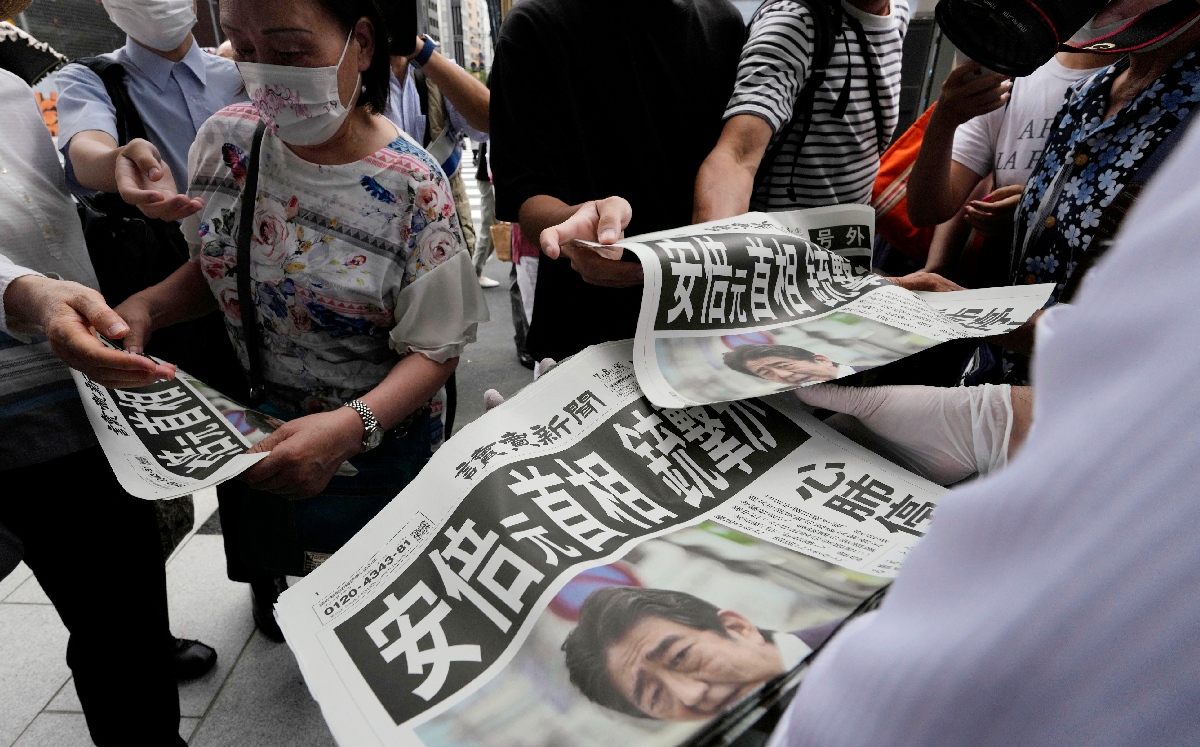 Un hombre distribuye ediciones extra del periódico reportando el asesinato del ex primer ministro. | AP