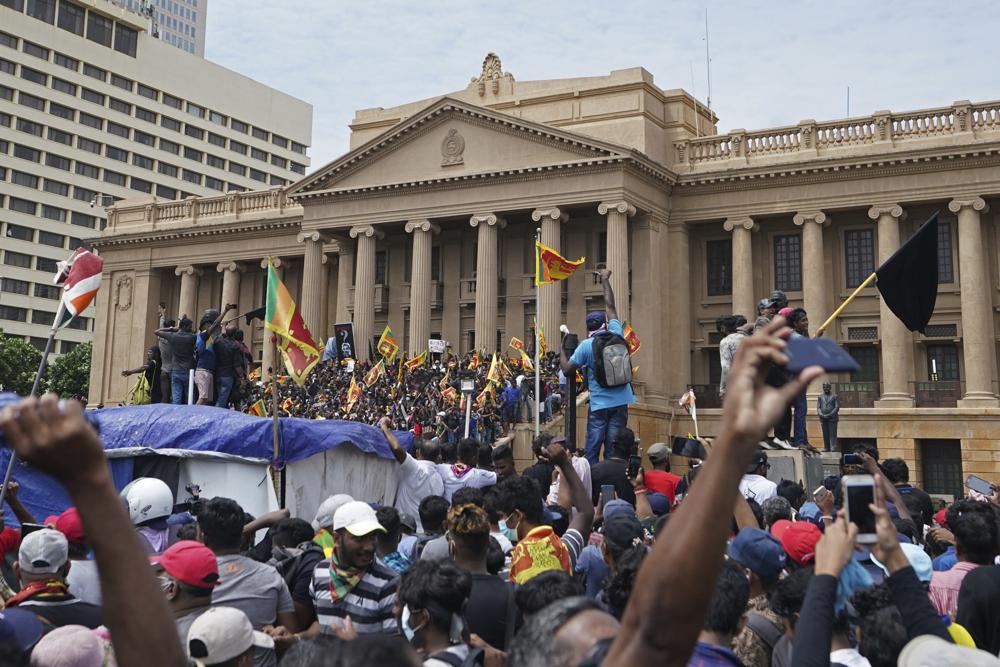 Manifestantes, muchos con banderas de Sri Lanka, se reúnen en torno a la oficina del presidente en Colombo | AP