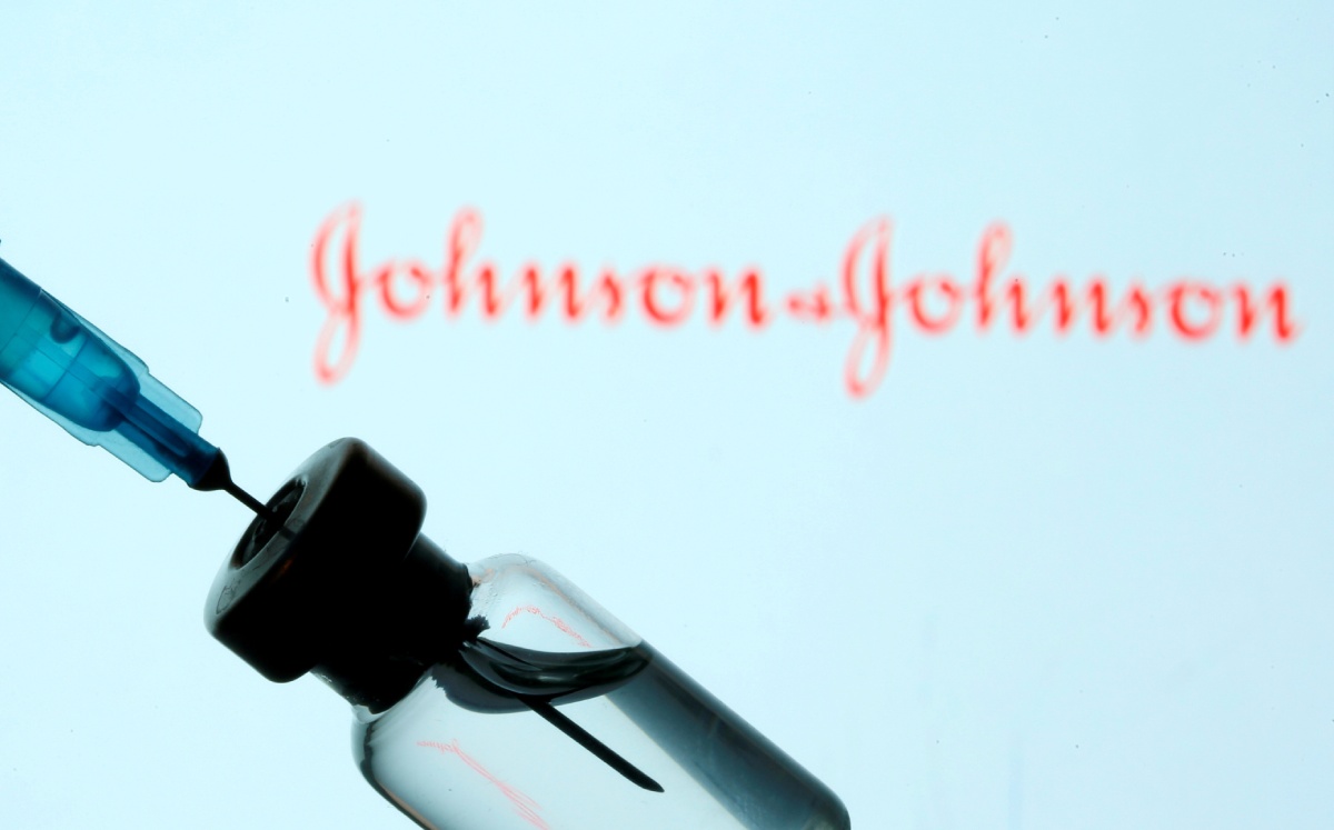 Una jeringa y un vial en frente de un logo de Johnson & Johnson. Enero del 2021. Foto: (Reuters)