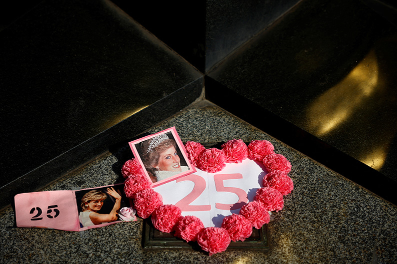Fotografías en memoria de la difunta princesa Diana se exhiben alrededor del monumento Liberty Flame sobre el túnel donde murió. |Reuters