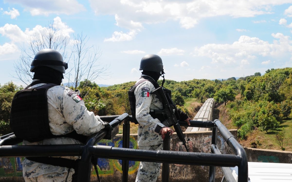 Integrants de la Guardia Nacional vigilan el paso de un tren. | Cuartoscuro