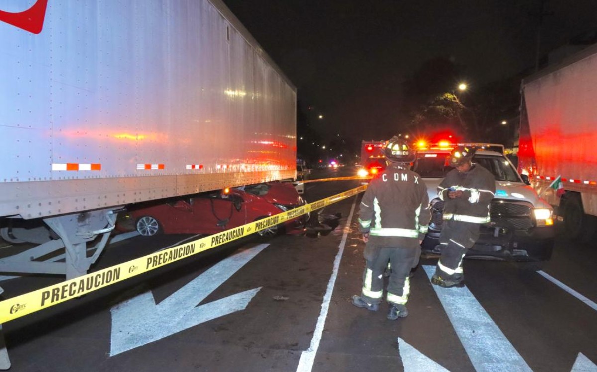 Elementos del cuerpo de bomberos, retiraron el automóvil que quedó incrustado en la parte baja del tráiler. | Luis Manuel Acevedo