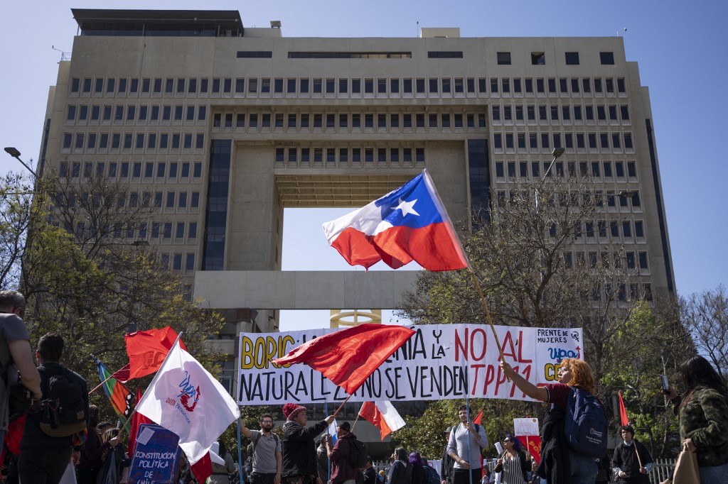 Decenas de personas protestando afuera del Congreso de Chile por la aprobación del TPP. (AFP)