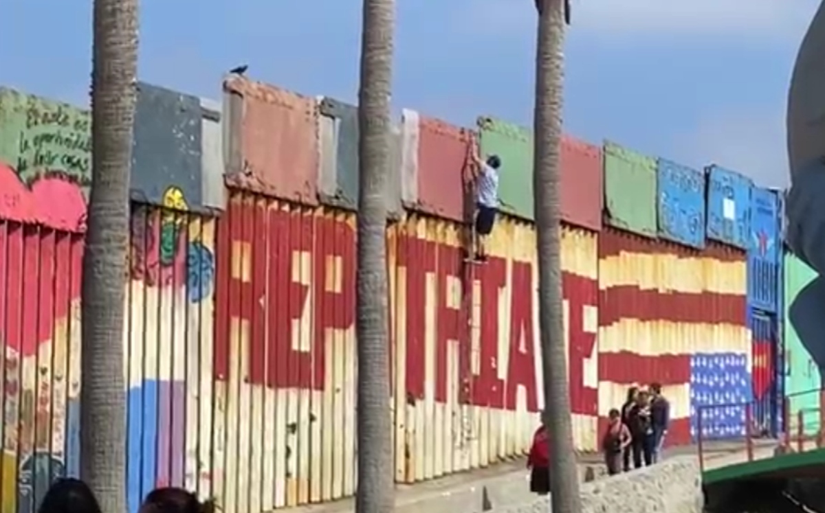 Traficantes de personas lanzan la escalera de metal para que los migrantes escalen el muro. | Especial
