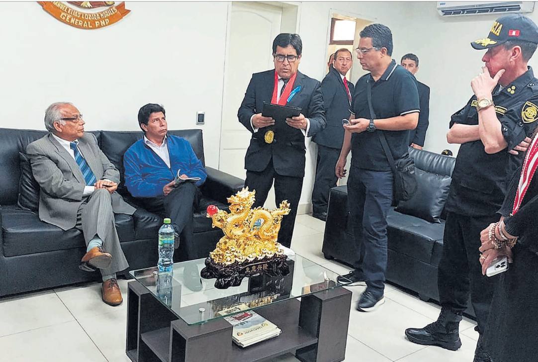 El ya ex presidente Pedro Castillo, detenido en la Procuraduría, ayer en Lima, rodeado de agentes policiales y fiscales anticorrupción. AFP