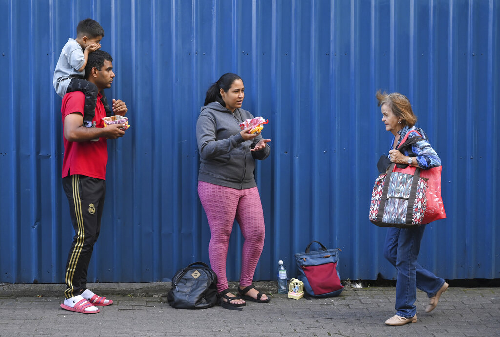 Migrantes venezolanos vendiendo golosinas en una calle de San José, Costa Rica. (AP)