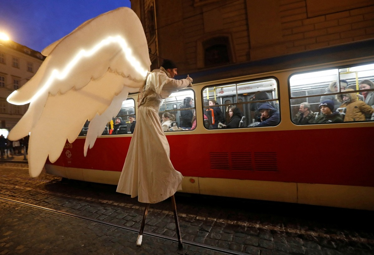 Un hombre vestido de ángel pasa junto a un tranvía como parte de las celebraciones navideñas en Praga, República Checa. | Reuters