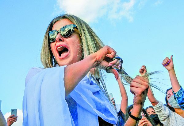 Mujer se corta el cabello durante manifestación por la muerte de Mahsa Amini. Reuters
