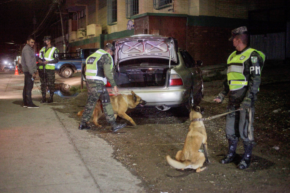 Un oficial de la Policía Militar de Honduras utiliza un perro rastreador durante una inspección de vehículos. (Reuters)