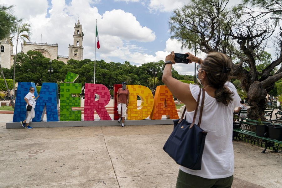 Una mujer toma una foto frente a una instalación que lleva el nombre de la ciudad el México, el 26 de mayo de 2021. (Xinhua/Luis Licona)