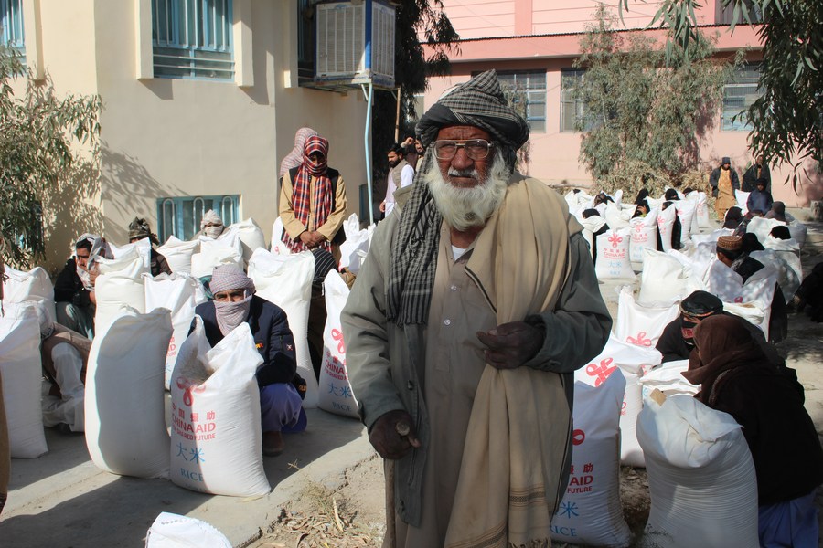 Afganos reciben ayuda humanitaria que donó China en la provincia de Nimroz, Afganistán, 20 de diciembre de 2022. (Aziz/Xinhua)