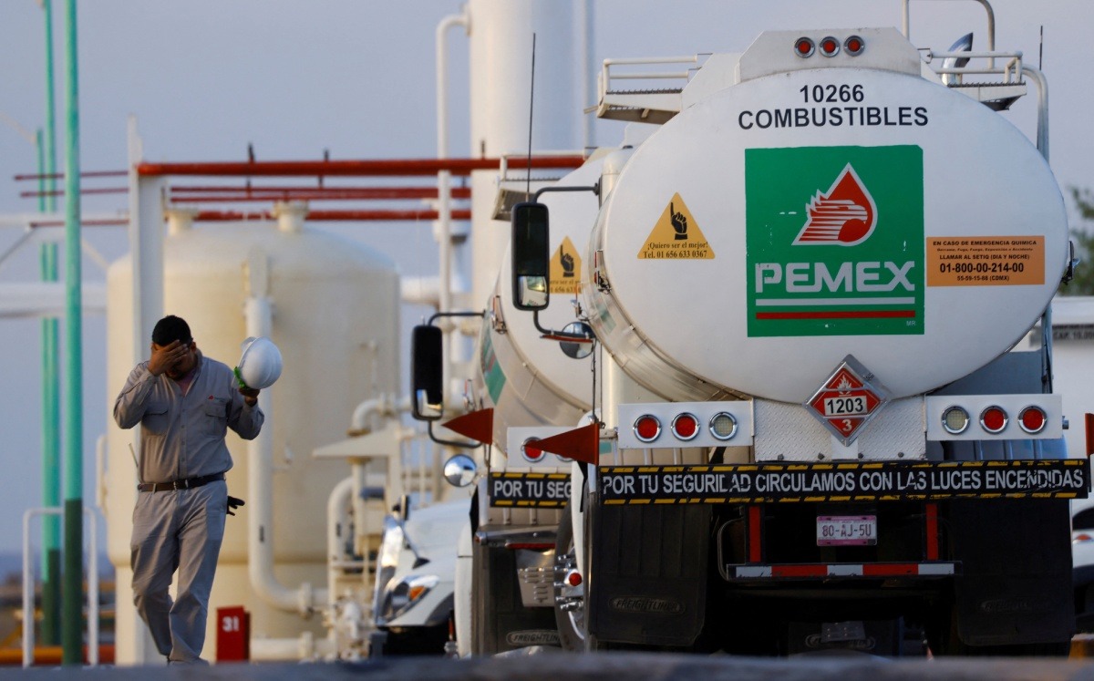 Trabajador camina cerca de un camión cisterna en centro de almacenamiento y distribución de combustible de Pemex. Junio de 2022. Foto: (Reuters)