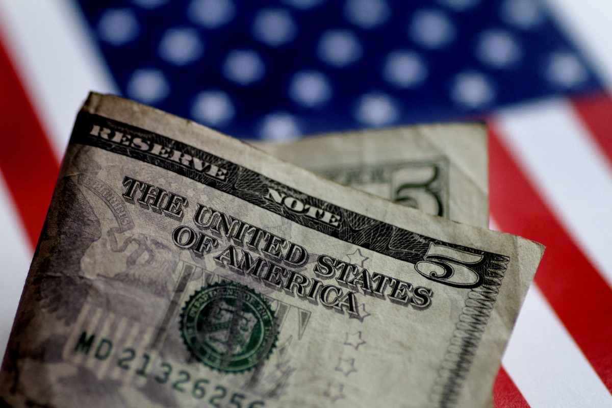 Dólar estadunidense con bandera de fondo. (Reuters)