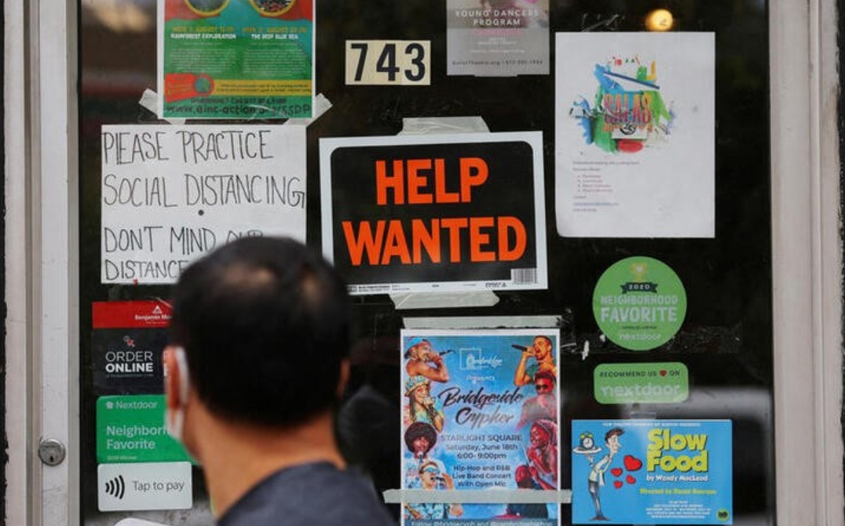 Una persona pasando junto a un cartel ofreciendo empleo en una tienda de Cambridge, Massachusetts, EU. Julio 2022. Foto: (Reuters)