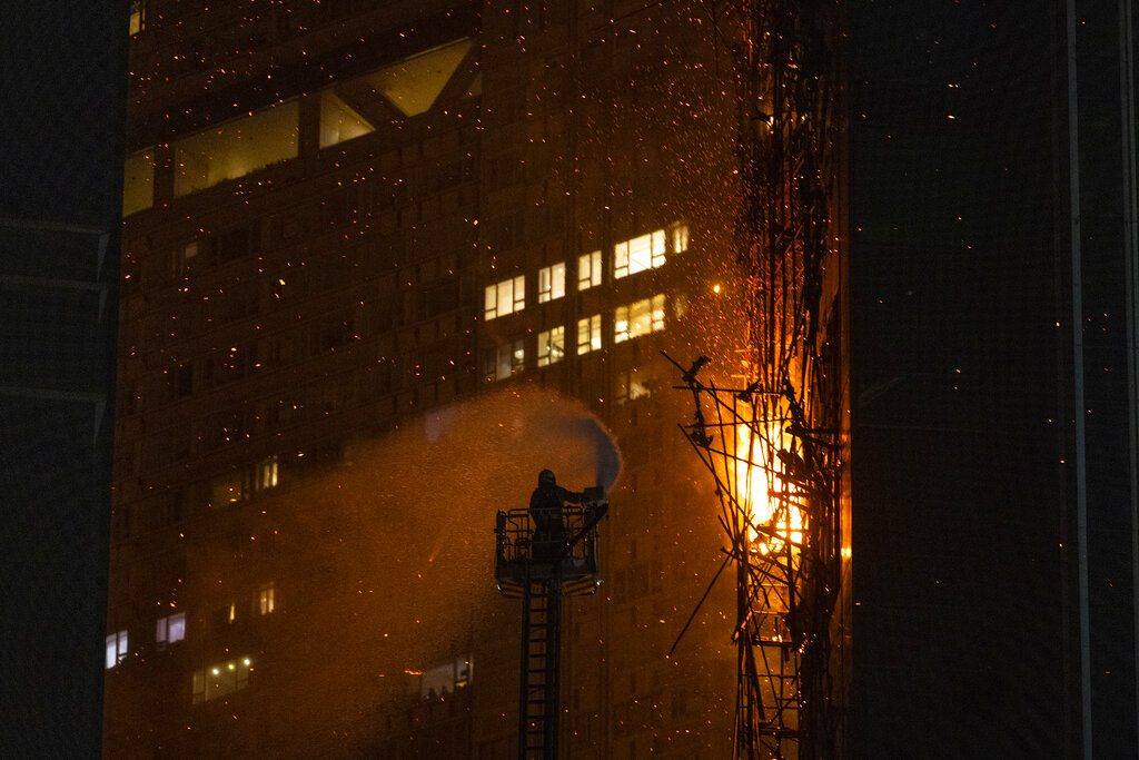 Un bombero rocía agua sobre un incendio en Hong Kong. (AP)