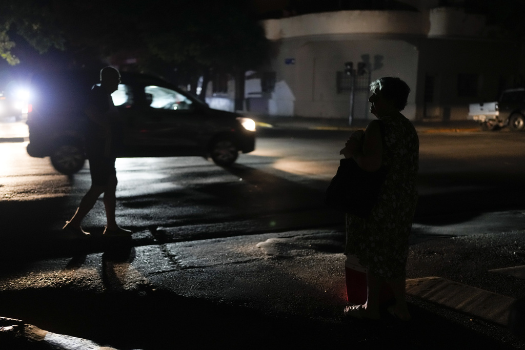 Una mujer se encuentra afuera de su casa durante un corte de energía en medio de una ola de calor en Buenos Aires, Argentina. (AP)