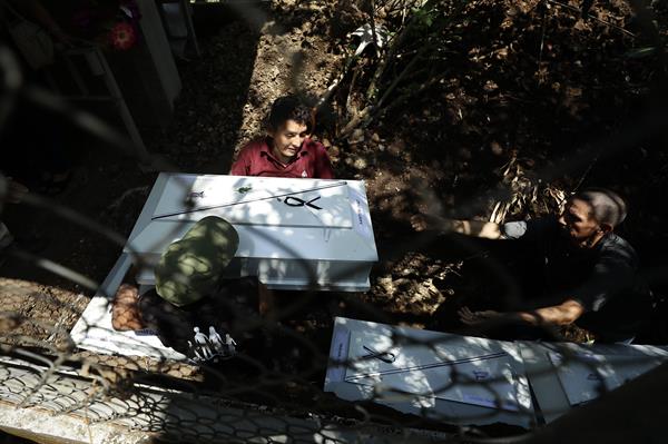 Familiares y sobrevivientes sepultaron los féretros que contienen los restos de víctimas de la masacre El Mozote. (EFE)