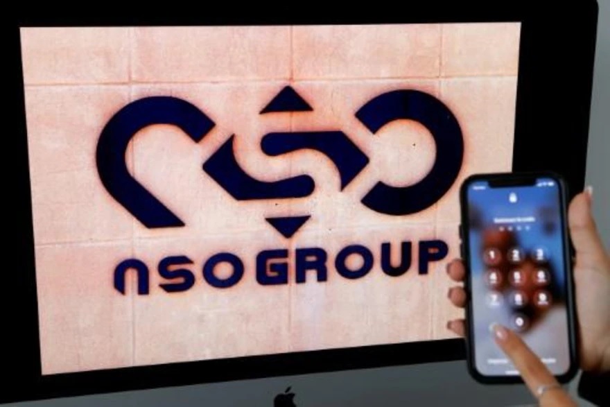 Un teléfono móvil, fotografiado junto a un logotipo del grupo NSO en Netanya, Israel. (AFP)