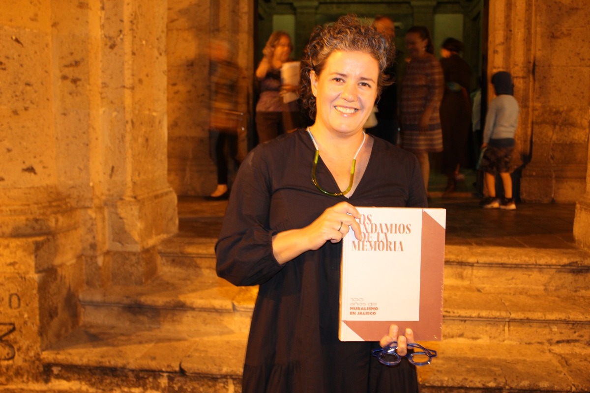 Lourdes González con el libro, ‘Los andamios de la memoria. 100 años de muralismo en Jalisco’ (Enrique Vázquez)