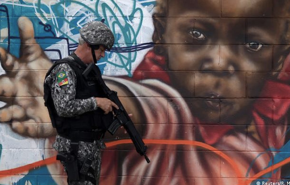 Miembro del ejército brasileño frente a mural de persona negra en Brasil (Reuters)