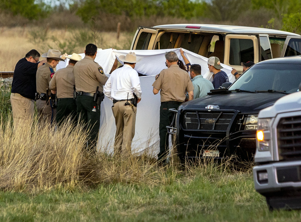 Agentes investigan el lugar donde varios migrantes fueron encontrados en dos vagones de un tren carguero. (AP)