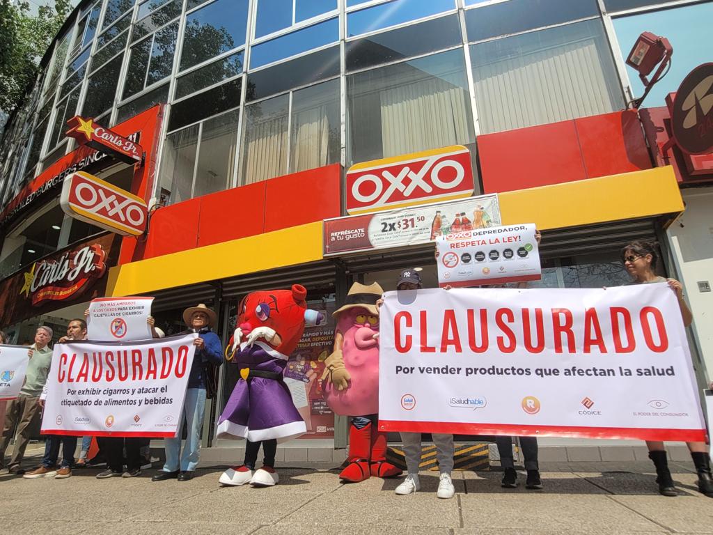 Organizaciones 'clausuran' Oxxo por exhibir cajetillas de cigarros. (Blanca Valadez)
