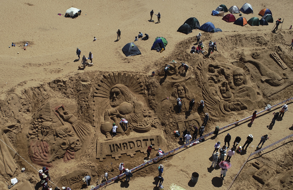Artistas trabajan en esculturas de arena como parte de las celebraciones del Viernes Santo en los Arenales de Cochiraya. (AP)
